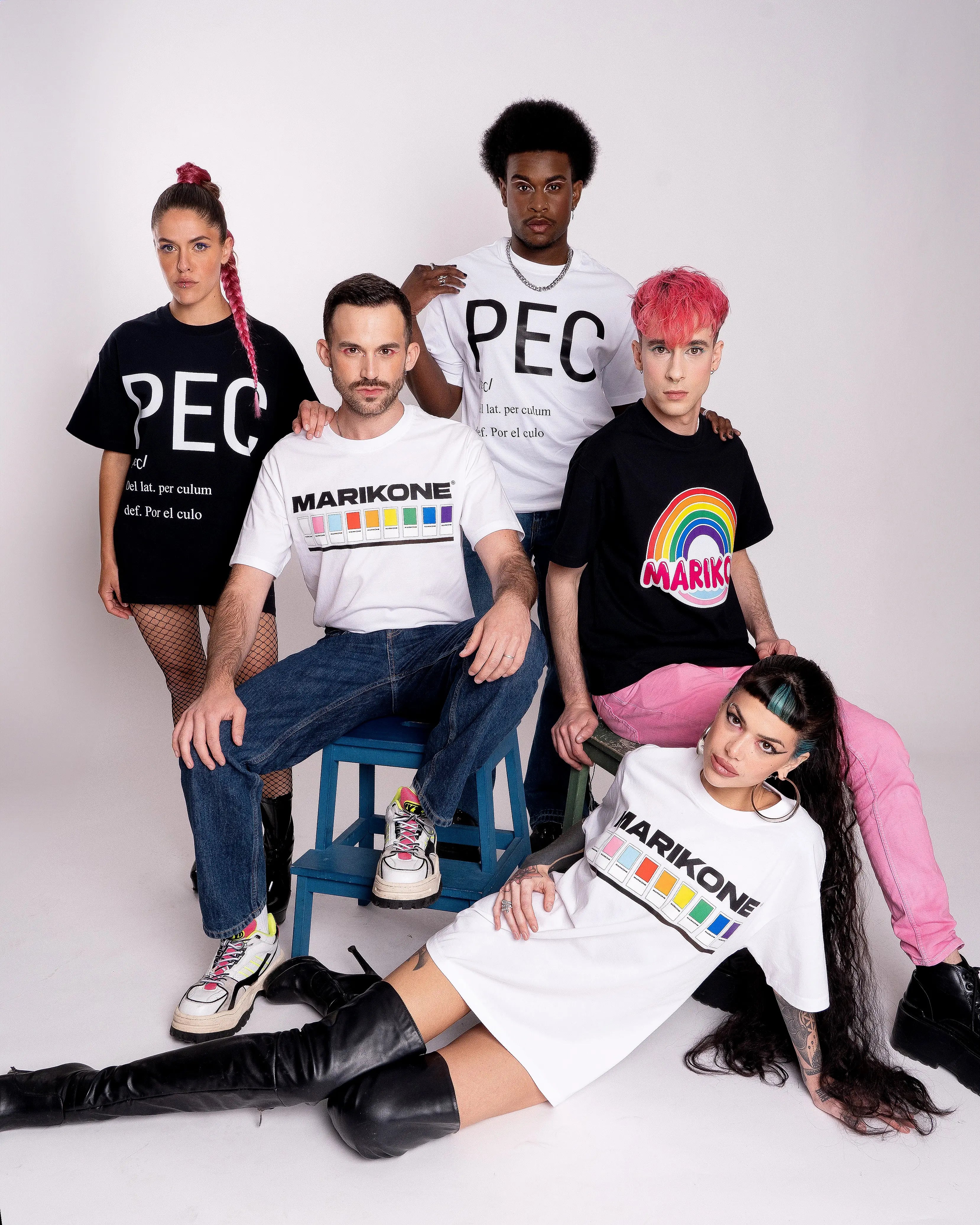 Foto grupal vertical de todos los modelos queer de la marca. Llevan las camisetas con motivos de Orgullo LGTBIQ+, MARIKONE PANTONE, arcoiris, bandera gay trans y camiseta que dice PEC (por el culo)