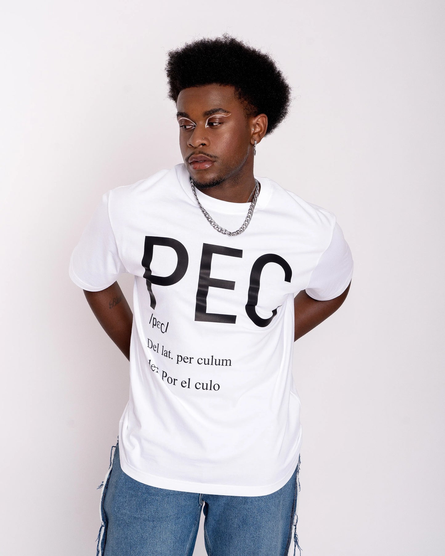 chico gay lleva camiseta blanca con letras negras grandes que dicen PEC, definición: por el culo. Una expresión de jóvenes, el colectivo LGTBIQ+, gay y Queer