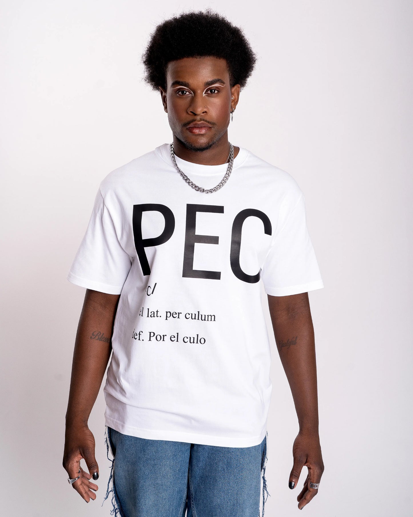 chico gay lleva camiseta blanca con letras negras grandes que dicen PEC, definición: por el culo. Una expresión LGTBIQ+ y Queer